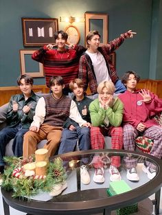 a group of people sitting on top of a couch in front of a christmas tree