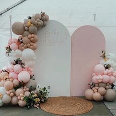 an arch with balloons and flowers on it