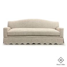 a beige couch with scalloped arms on a white background