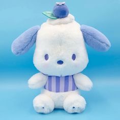 a white stuffed animal wearing a purple and white striped shirt with a blue bird on it's head