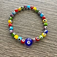 Multi Colored Evil Eye Bracelet. One Size. Handmade Lampwork Blown Glass Beads. One Size Fits All Multicolor 8mm Beads Evil Eye Bracelet, Adjustable Multicolor Evil Eye Beads, Multicolor Evil Eye Bracelet With Colorful Round Beads, Casual Multicolor Beaded Evil Eye Bracelet, Adjustable Multicolor Evil Eye Bracelet With 8mm Beads, Multicolor Beaded Bracelets With Evil Eye, Bohemian Multicolor Round Beads Evil Eye Bracelet, Glass Bracelet, Eye Bracelet