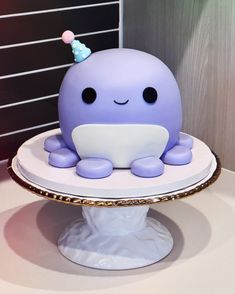 a purple and white cake sitting on top of a table