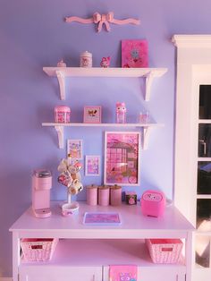 a doll house with pink furniture and accessories on the shelf above it is decorated in pastel colors