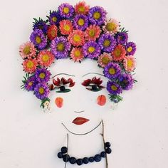 a woman's face with flowers in her hair and beads on the necklaces