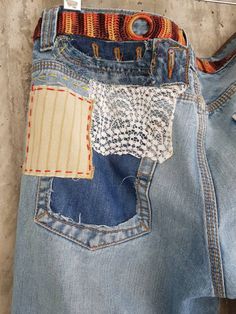 an old pair of jeans with patches and lace on them