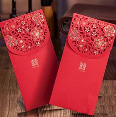 two red envelopes sitting on top of a wooden table