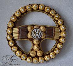 a car steering wheel made out of chocolates and gold foiled eggs with the word volkswagen written on it