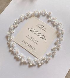 a white paper with pearls on it next to a pair of scissors