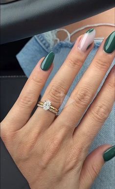 a woman's hand with green and white manicured nails, holding a ring