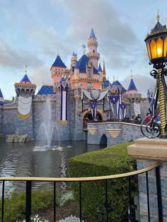 a bike is parked in front of a castle with a fountain and lights on it