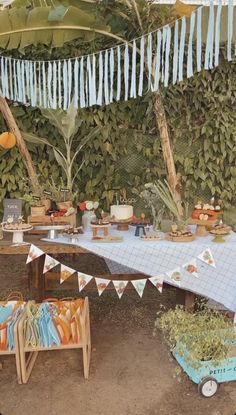 an outdoor party is set up with blue and orange decorations, buntings and flags