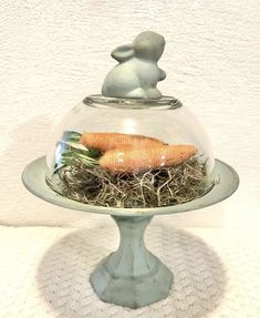 there is a glass bowl with some food in it on top of a plate that has grass inside