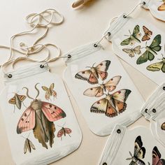 some butterflies are hanging from tags on a table