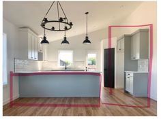 an empty kitchen with white cabinets and pink trim on the countertop is shown in this image