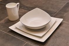 two white plates and a cup on a tile floor