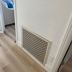 a white radiator sitting on top of a wooden floor next to a wall