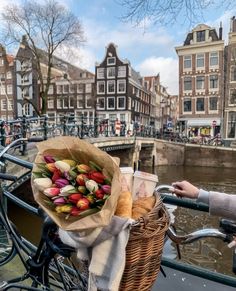 a basket filled with lots of colorful flowers next to a bike parked on the side of a street