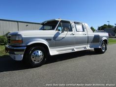 a silver truck parked on the side of a road next to a tall metal building