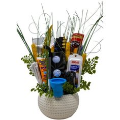 a white vase filled with lots of different types of golf related items and plants in it