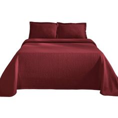 a bed with red sheets and pillows on it's headboard, in front of a white background