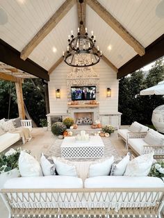 an outdoor living room with white furniture and chandelier