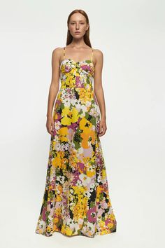 a woman in a long dress with flowers on it