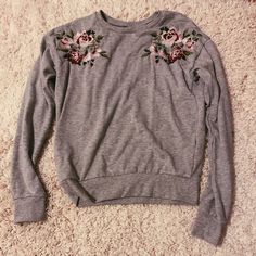 Grey Crewneck !! Has Flowers Embroidered On Each Side And Bought In Europe. Never Worn Before And In Great Condition ! Spring Floral Embroidered Crew Neck Sweatshirt, Spring Long Sleeve Tops With Embroidered Graphics, Pink Cotton Sweatshirt With Floral Embroidery, Cute Floral Embroidery Crew Neck Tops, Spring Long Sleeve Sweatshirt With Floral Embroidery, Spring Floral Embroidery Long Sleeve Sweatshirt, Spring Floral Embroidered Long Sleeve Sweatshirt, Casual Embroidered Tops With Flower Shape, Spring Pink Sweatshirt With Embroidered Graphics