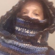 a woman is wearing a crocheted scarf