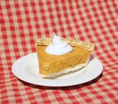 a piece of pie on a plate with a red and white checkered tablecloth