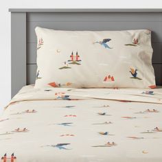 an image of a bed with birds and mountains on the sheet set that is made up