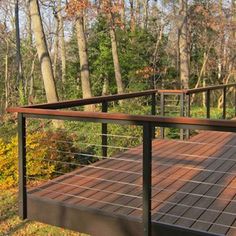 a wooden deck with metal railings in the woods