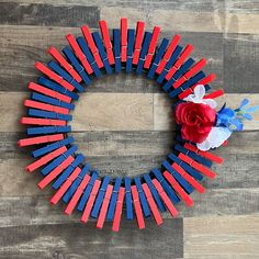 a wreath made out of red, white and blue sticks with a flower on top