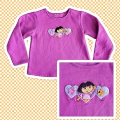 "Vintage Dora The Explorer Pink Embroidered Sweatshirt Sz Kids Small This is a vintage Dora The Explorer themed sweatshirt. The shirt is long sleeved and has an embroidered Dora with hearts on the center chest. The overall condition is good, there is some minor peeling. Colors: Pink Material : 100% Cotton Blend Quality Rating:  Tag Size: Kids Small  - Made in: Unknown - Brand: Nickelodeon Measurements shown in pictures are taken while garment is laid flat  14\" Pit to Pit - 16\" long from top collar to bottom hem 13\" from pit to edge of sleeve. Great preowned condition. No Holes, Stains or Bad Odors. See Pictures for Details." Pink Long Sleeve Sweatshirt With Embroidered Logo, Cotton Long Sleeve Top With Appliques, Cute Long Sleeve Embroidered T-shirt, Vintage Embroidered Cotton Sweater, Cotton Long Sleeve T-shirt With Embroidered Graphics, Long Sleeve Cotton T-shirt With Embroidered Graphics, Pink Long Sleeve Sweatshirt With Custom Embroidery, Long Sleeve T-shirt With Embroidered Logo For Fall, Pink Long Sleeve Sweater With Embroidered Logo