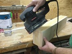 a person using a sander on a piece of wood