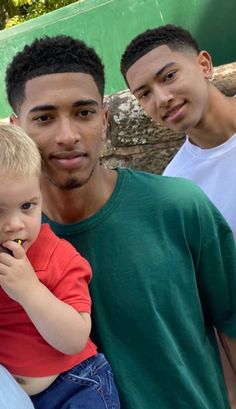 two men and a little boy posing for a picture