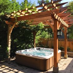 a hot tub sitting under a wooden pergol