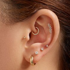 a woman with three different ear piercings on her left side, and two smaller ones in the middle