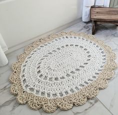 a crocheted doily is on the floor in front of a bathtub