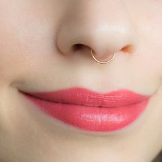 a close up shot of a woman's nose with a ring on it