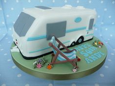 a birthday cake shaped like a camper with a lawn chair on it's side