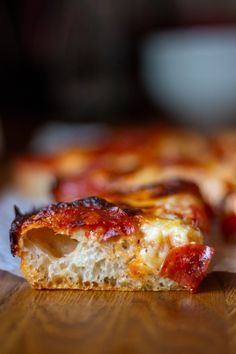 a piece of pizza sitting on top of a wooden table