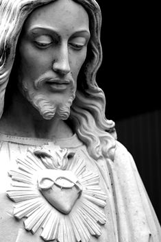 a statue of jesus with his eyes closed and heart in the middle of his chest