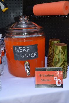 an orange liquid in a glass jar next to other items