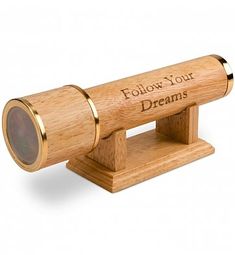 a wooden telescope with the words follow your dreams engraved on it