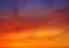 an orange and blue sky with some clouds in the background at sunset or sunrise time