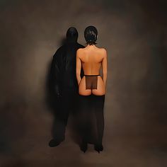 two people standing next to each other in front of a dark background with the shadow of a man and woman