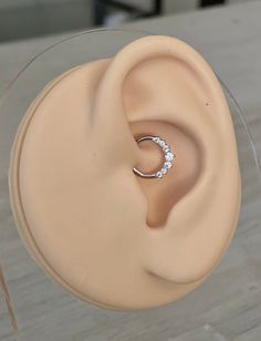 an open ear with a diamond ring in it's middle, sitting on top of a table