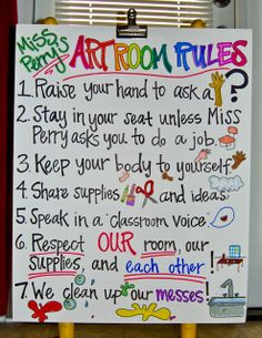 a white sign with writing on it sitting in front of a door that says art room rules