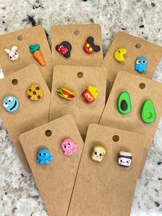 six different colored plastic buttons on top of brown paper bags with holes in the middle