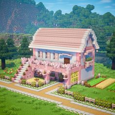 a pink house in the middle of a lush green field with trees and bushes around it